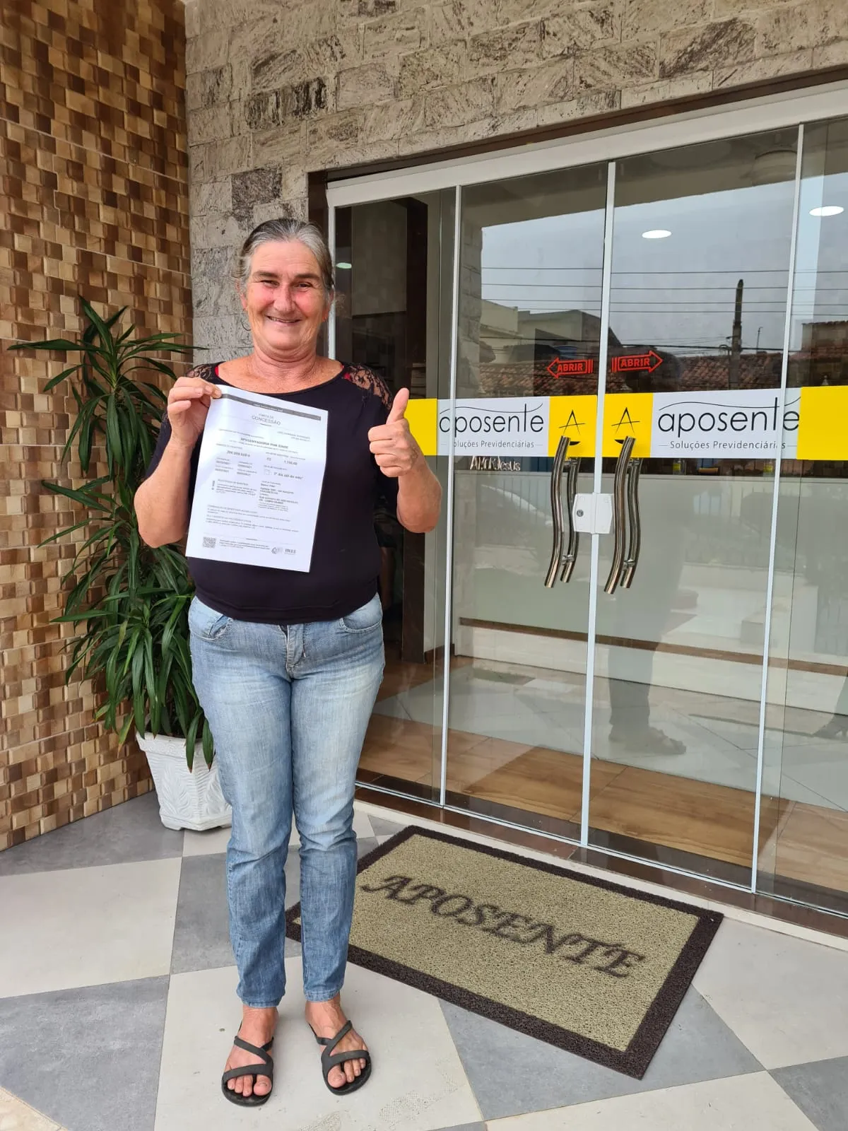 Cliente idosa comemorando benefício BPC LOAS na entrada da Aposente